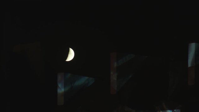 Half moon shining in the sky over the house roof at night. Glitch. Medium shot
