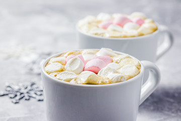 Hot winter drinks and christmas lights, snowflakes, marshmallows. Selective focus, close up. 
