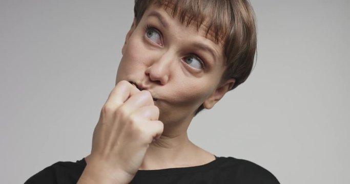 Happy smiling attractive young woman brushing her teeth with black toothpaste and having fun