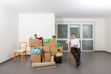 Mann trinkt sitzend Kaffee. Er macht kurze Pause beim Einzug in neue Wohnung