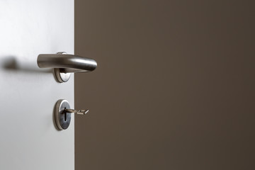 Fototapeta premium Blick durch eine offene Türauf eine braune Wand