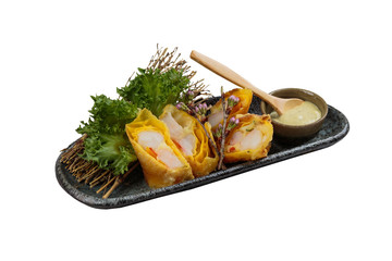 Isolated Omelette wrap kani (crab stick) served with lettuce and wasabi salad dressing in grey stone plate.
