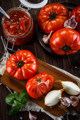 Raw tomatoes and tomato sauce in jar
