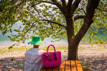 Woman watching beach lake sitting on wooden table