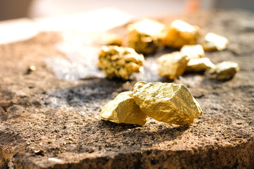 The pure gold ore found in the mine on a stone floor - obrazy, fototapety, plakaty