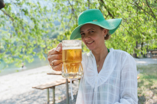 Woman toasting with a glass of freshly beer