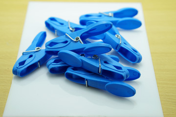  Closeup Blue Cloth pins on white plastic background