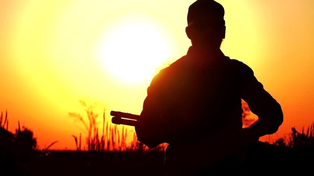 man with shotgun quickly aim in sunset 24fps 4k