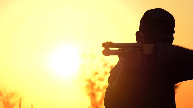 man aim and turns towards camera with shotgun 4k
