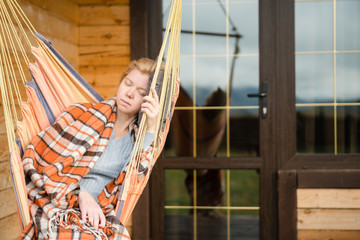 Obraz na płótnie Canvas Woman resting in hammock outdoors.