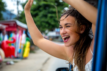smiling girl looks out of the window of a taxi