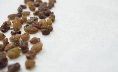 Pile on left side of raisins isolated on grey background