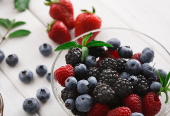 Fototapeta na wymiar Mixed berries in glass bowls closeup, selective focus