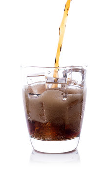 Bottle pouring Cola in drink glass with ice cubes