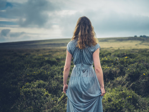 Beautiful young woman in dress on the moor