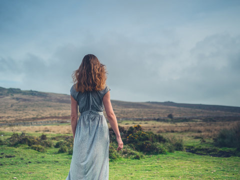 Beautiful young woman in dress on the moor