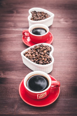 Background on a theme of coffee with place for text. Two cups of coffee, espresso, coffee beans, wooden table.