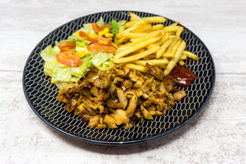 Chicken with sauce and golden French fries potatoes