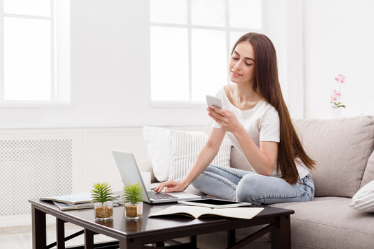 Pretty Girl Texting On Mobile At Home On The Couch. Dark-haired Girl In Casual