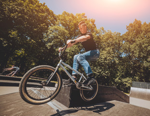 Bmx rider performing tricks at skatepark.