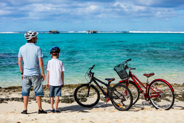 Fototapeta premium Father and kids at beach with bikes