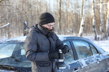 Man drink hot tea from mug outdoor in winter day
