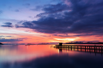 Fototapeta na wymiar scenery view of old jetty to the sea beautiful sunrise or sunset dramatic sky in phuket thailand.