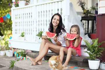A young girl in a country house in nature eating a watermelon