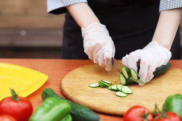The cook cuts fresh farm vegetables