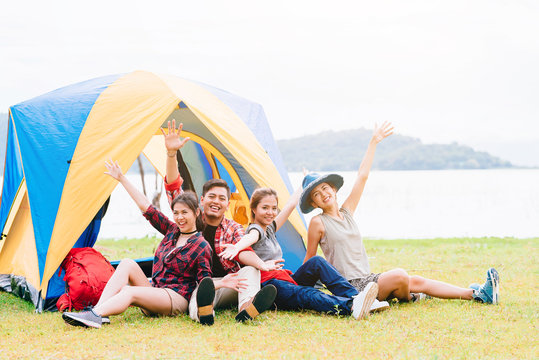 Happy Asian friends having a good time together while travel camping vacation trip by the lake
