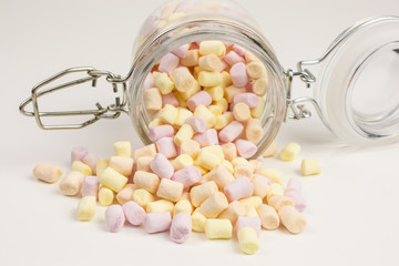 tiny marshmallows in yellow, orange and pink in a glass jar