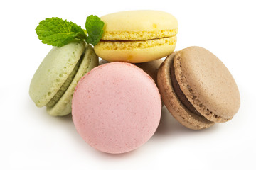 french sweet macaroons  in pink, yellow, green and brown with mint