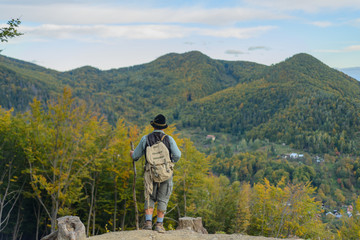 Senior tourist man trekking in the mountains, place for writing text.