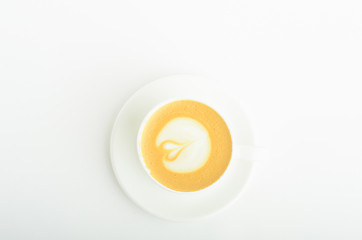 A cup of cappuccino coffee with heart shaped milk foam isolated on white background