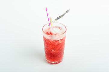Red berry lemonade with ice decorated lavender in glass isolated on white background