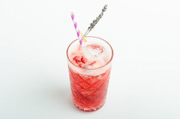 Red berry lemonade with ice decorated lavender in glass isolated on white background