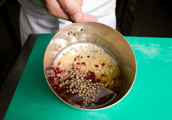 Diced organic golden beetroot, diced purple beetroot and diced truffles, in a metal frying pan with olive oil ready for frying.