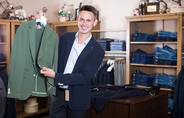 Smiling male customer searching new jacket