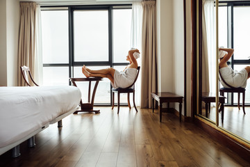 Woman after shower relax in hotel room near the panorame window