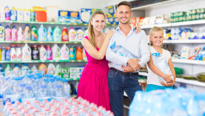  young family of three choosing  water in grocery market