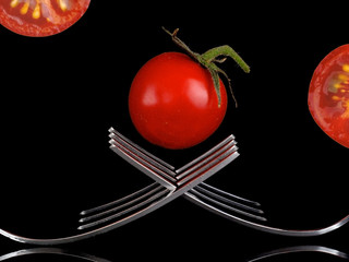 Tomato and forks, creative design with reflection.