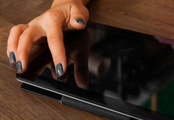 woman's hand pointing , touching and using tablet on a wooden background.