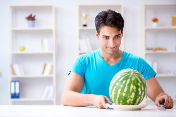 Man eating watermelon at home