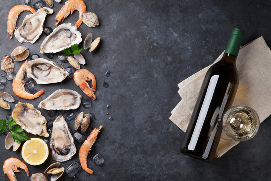 Fresh seafood and white wine on stone table