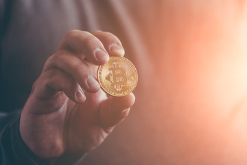 Fototapeta na wymiar Cryptocurrency golden bitcoin coin in man hand