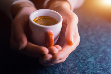 The girl is holding a cup of American coffee.