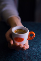 The girl is holding a cup of American coffee.