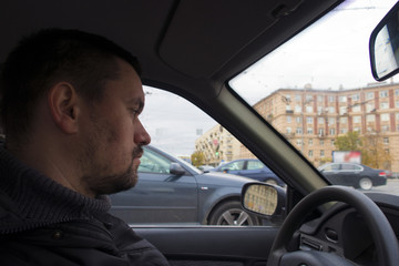 a man driving a car rides around the city