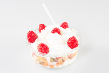 Fresh fruits salad with ice cream in bowl on table on bright background