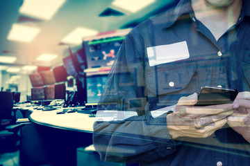 Double exposure of  Engineer or Technician man in working shirt  working with smart phone in control room of oil and gas platform or plant industrial for monitor process, business and industry concept